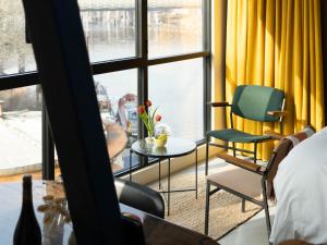 a room with a bed and a table and chairs at De Bossche Kraan in Den Bosch