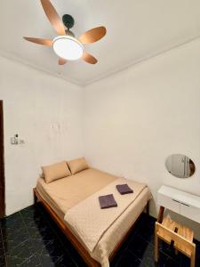 a bedroom with a bed with a ceiling fan at Desa Huis Yogyakarta in Gandok