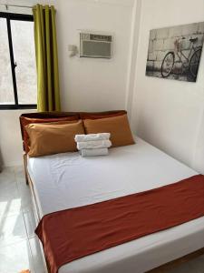 ein Schlafzimmer mit einem Bett mit weißen Laken und braunen Kissen in der Unterkunft Leonardo Hostel in Anda + 1 Foto