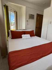 ein Schlafzimmer mit einem großen Bett mit rot-weißer Bettwäsche in der Unterkunft Leonardo Hostel in Anda