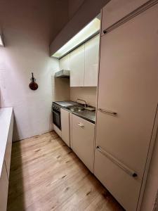 a small kitchen with a sink and a stove at HappyLaax - Panoramic Penthouse - Pool, Sauna & Private Parking in Laax
