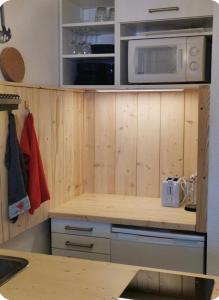 a kitchen with wooden cabinets and a microwave at Jonquille 5 personnes in Chamonix