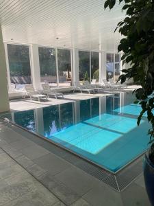 a swimming pool with lounge chairs in a building at HappyLaax - Panoramic Penthouse - Pool, Sauna & Private Parking in Laax