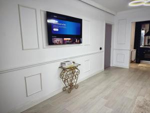 a living room with a television on a wall at Boutique Apartment in Ploieşti