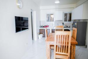 a kitchen with a wooden table and chairs in it at Jannish Transient House in Masbate