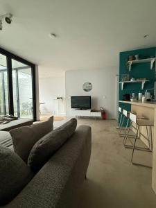 a living room with a couch and a television at Maison Bonheur in Bruges