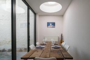 a dining room with a wooden table and chairs at Maison Bonheur in Bruges