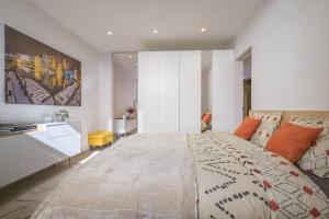 a bedroom with a large bed with orange pillows at Maison Bonheur in Bruges