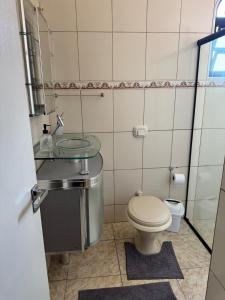 a bathroom with a toilet and a glass sink at Casa Brisa do Mar in Governador Celso Ramos +21 photos