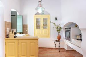a kitchen with yellow cabinets and a table at Villa Matakia in Áno Potamiá