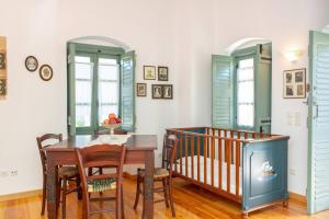 a dining room with a table and a crib at Villa Matakia in Áno Potamiá +59 photos