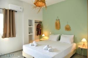 a bedroom with a white bed with towels on it at Nuevo Vista in Kavos +125 photos