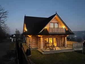a log cabin with a table in front of it at Cicha Ostoja in Czarny Dunajec