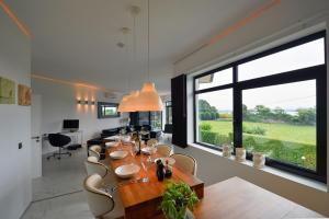 a dining room with a table and a large window at Aurora Villa in Lesa