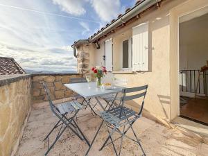 a table and chairs on the balcony of a house at Maison rénovée avec terrasse et parking privé in Mallemort
