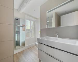 a white bathroom with a sink and a mirror at Maison rénovée avec terrasse et parking privé in Mallemort +30 photos