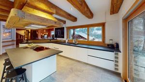 a kitchen with white cabinets and a black counter top at Chalet Chavanette - Beautiful 7 bedrooms Chalet in Champéry