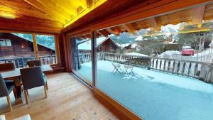 a large screened in porch with a table and chairs at Chalet Chavanette - Beautiful 7 bedrooms Chalet in Champéry