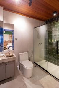 a bathroom with a toilet and a glass shower at Villa Hortensia in Mucugê +79 photos