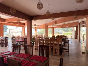 a restaurant with wooden tables and chairs with red tablecloths at Atarah Beach Hotel in Negombo