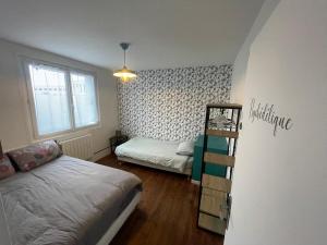 a bedroom with a bed and a book shelf in it at Maison proche Naval Group in Lanester