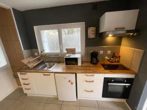 a small kitchen with a sink and a microwave at Maison proche Naval Group in Lanester +15 photos