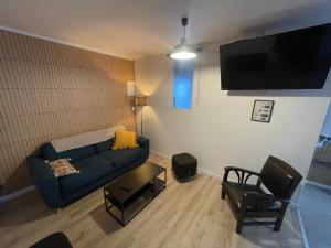 a living room with a blue couch and a tv at Maison proche Naval Group in Lanester