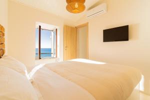 a white bedroom with a bed and a window at Casa Anciua in San Bernardino