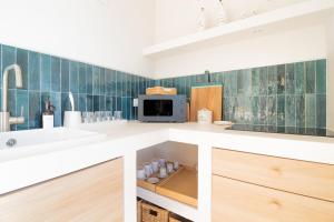 a kitchen with a sink and a microwave at Casa Anciua in San Bernardino