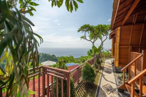 a balcony with a view of the ocean at Kubu Diar by Manara in Seraya