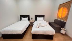 a room with two beds and a couch at สังข์เงินรีสอร์ท2 in Nakhon Sawan