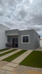 a house with a grass yard in front of it at Casa nova e aconchegante em condomínio in Petrolina