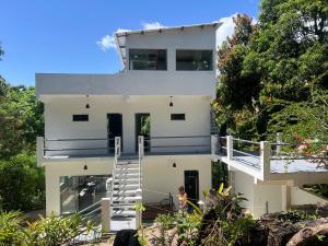 a white house with a staircase in front of it at Maison das Artes morere in Cairu