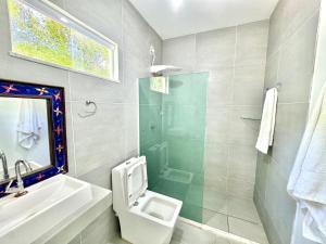 a bathroom with a toilet and a sink and a shower at Maison das Artes morere in Cairu