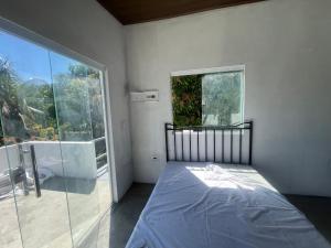 a bedroom with a bed and a large window at Maison das Artes morere in Cairu +20 photos