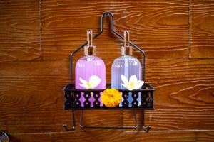 two glass bottles on a rack on a wooden wall at Kubu Diar by Manara in Seraya +23 photos