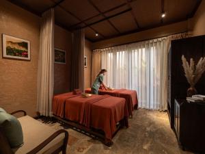 a person standing at two tables in a room at La Lua Resort Ninh Binh in Ninh Binh