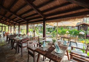 a dining room with wooden tables and chairs at La Lua Resort Ninh Binh in Ninh Binh