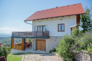 a white house with a balcony and a patio at Vineyard cottage Mehak in Telče