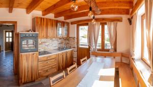 a kitchen with wooden cabinets and a stove top oven at Vineyard cottage Mehak in Telče