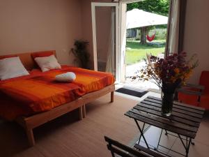 a bedroom with a bed and a table and a window at Studio Lumineux avec jardin & piscine à Vaison la Romaine in Vaison-la-Romaine +31 photos