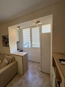 a living room with a couch and a window at Forum Apartment in Stara Zagora +2 photos