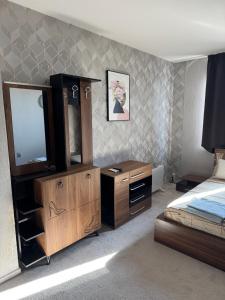 a bedroom with a bed and a dresser and a mirror at Forum Apartment in Stara Zagora