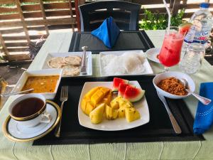 a table with a plate of food on a table at Shereen Sigiri Homestay in Dambulla