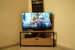 a flat screen tv sitting on a tv stand at Studio - Free Parking - Netflix - Wi-Fi in Brive-la-Gaillarde +4 photos