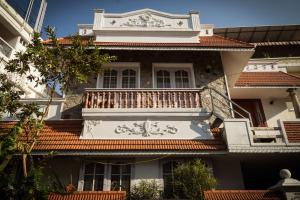 a white building with a balcony on top of it at IDANN Homestay in Cochin
