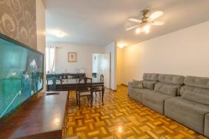 a living room with a couch and a large tv at Espaçoso e Confortável Próximo da UEM - EL08 in Maringá
