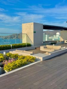 a rooftop deck with flowers and a building at 5El apartamento que todos quieren in Santa Marta