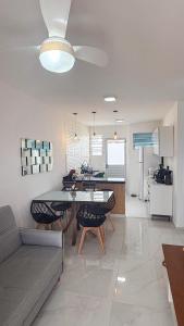 a kitchen and living room with a table and a couch at Casa nova e aconchegante em condomínio in Petrolina