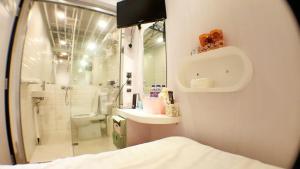 a bathroom with a shower and a sink and a toilet at In Inn in Hong Kong